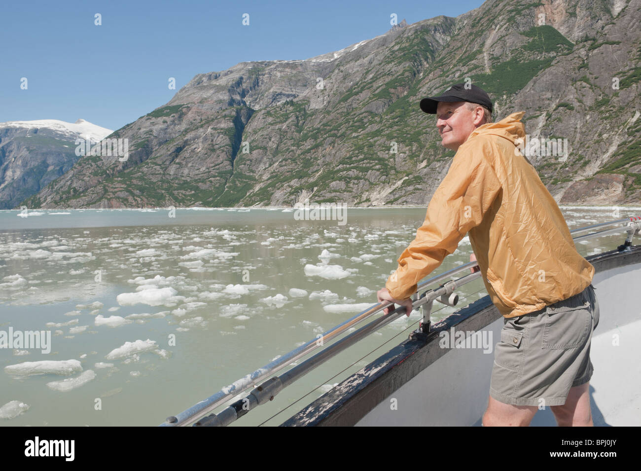 L'uomo gode di spettacolari paesaggi di montagna e ghiaccio bergs mentre su una crociera in Alaska nel Tracy Arm Fjord. Foto Stock