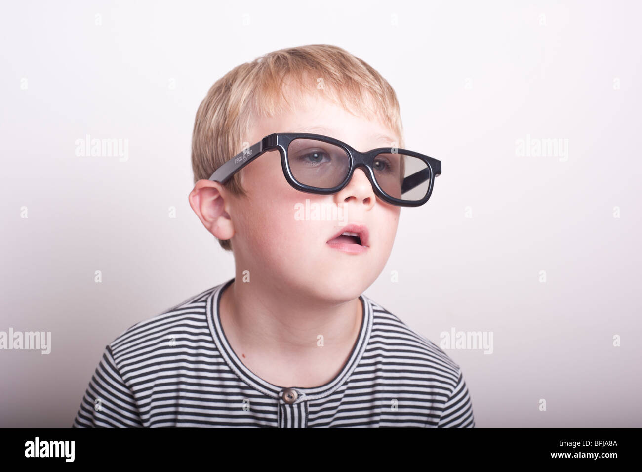 Un modello rilasciato una foto di un 6 anno vecchio ragazzo che indossa un paio di reale occhiali 3d in studio Foto Stock
