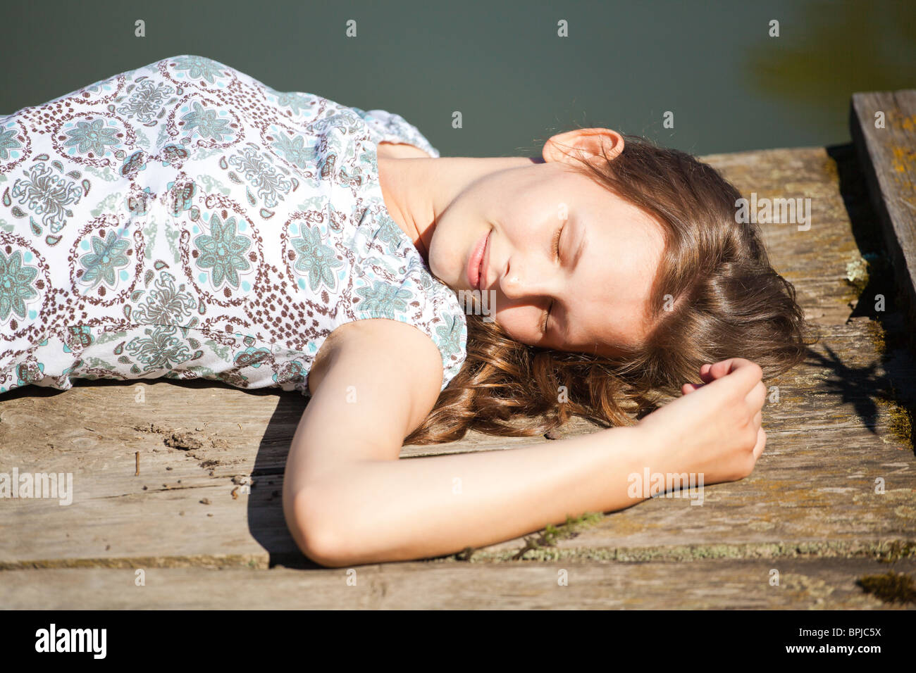 Bella giovane donna rilassante dal lato di un lago. Foto Stock