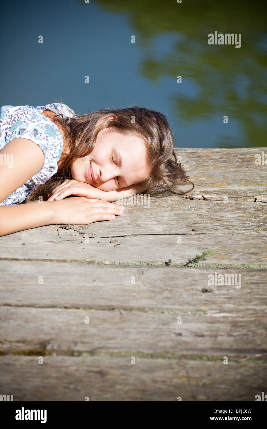 Bella giovane donna rilassante dal lato di un lago. Foto Stock