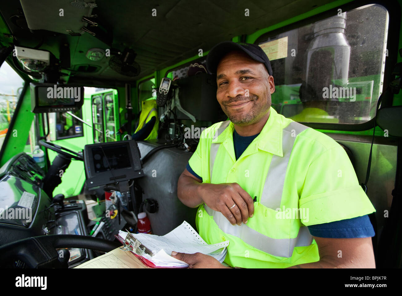 African American uomo alla guida di camion della spazzatura Foto Stock