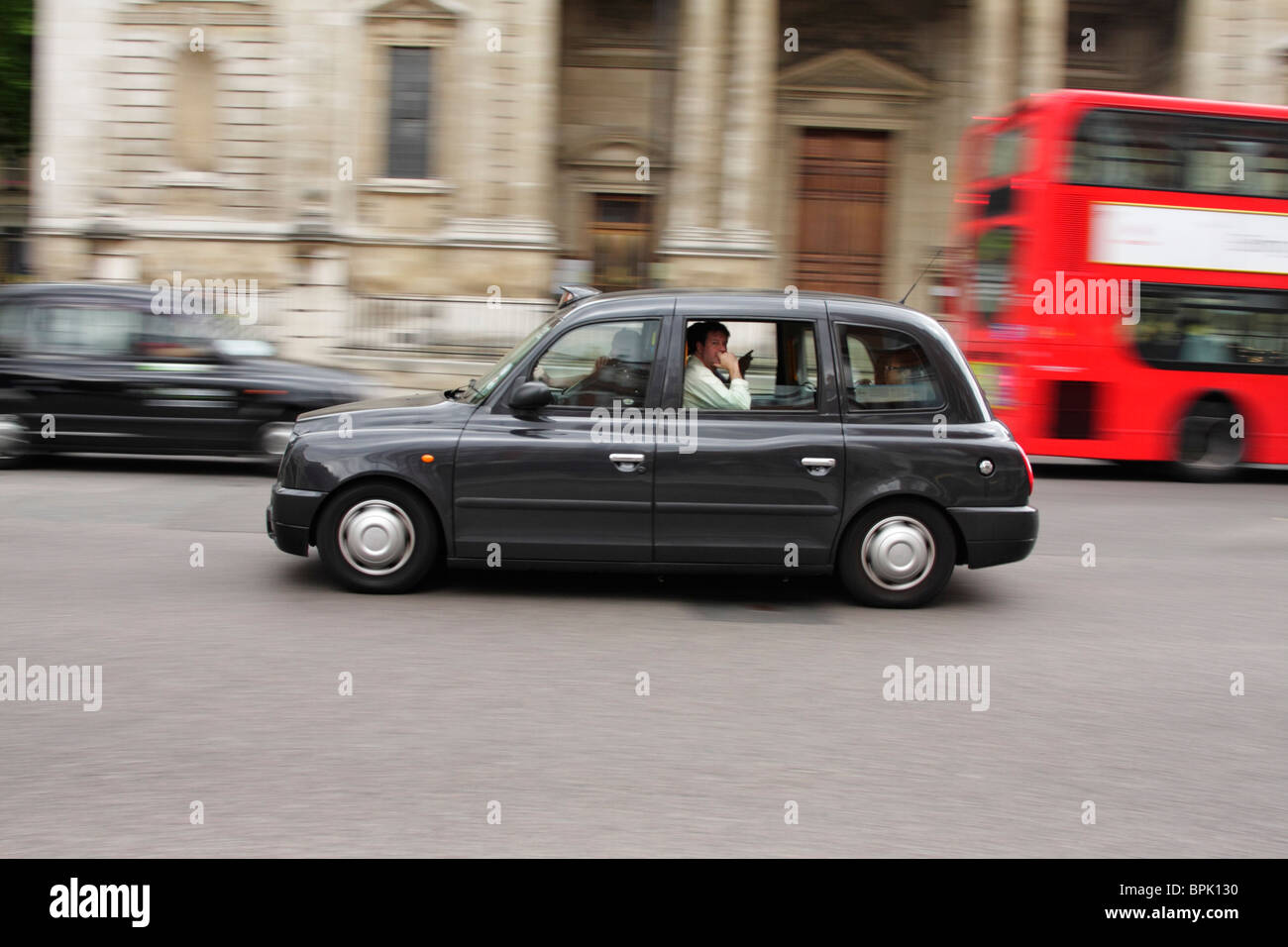 Un 'black cab' accelerazione attraverso le strade di Londra Foto Stock