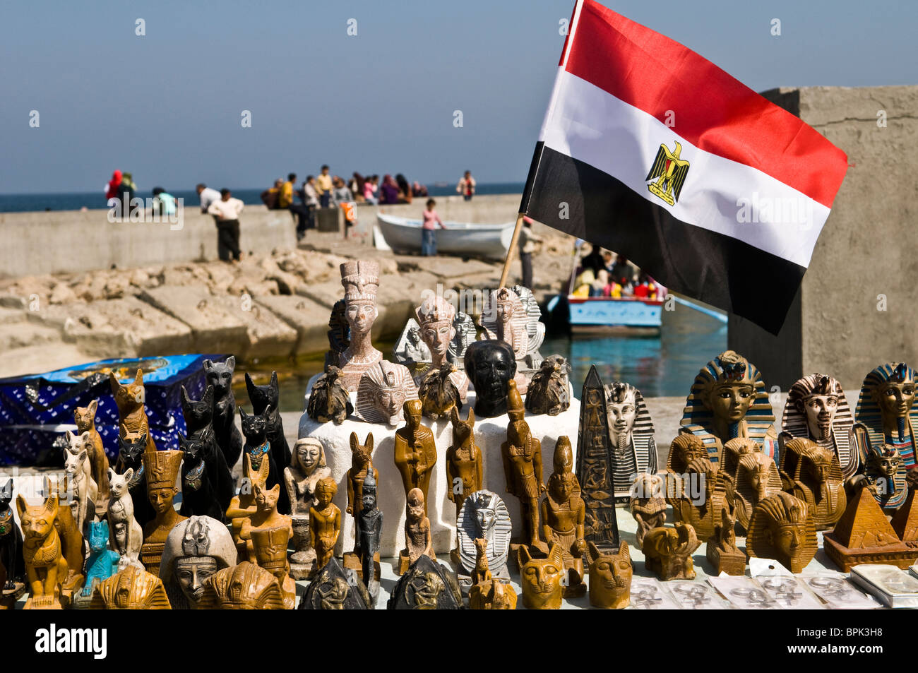 La bandiera egiziana e altri souvenir venduti nelle vicinanze del Fort Qaitbey in Alessandria, Egitto. Foto Stock