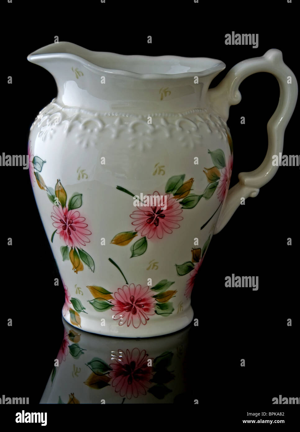 Questa immagine di stock è un color crema, acqua floreale bricco per home decor accent utilizzare, isolata su uno sfondo nero Foto Stock