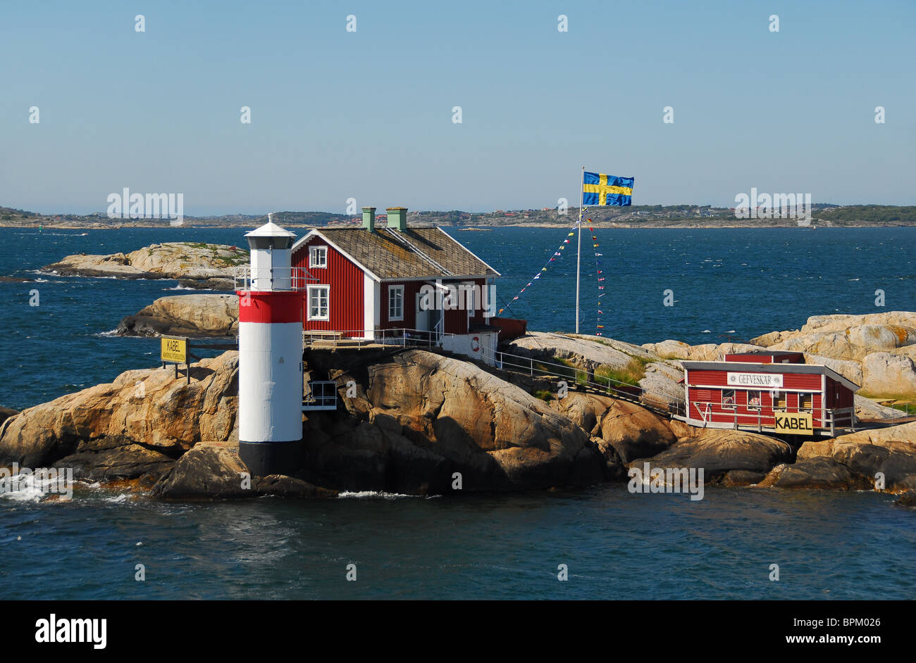La quintessenza Falu-rosso casa svedese si siede oltre uno dei piccoli fari al di fuori di Göteborg. Foto Stock