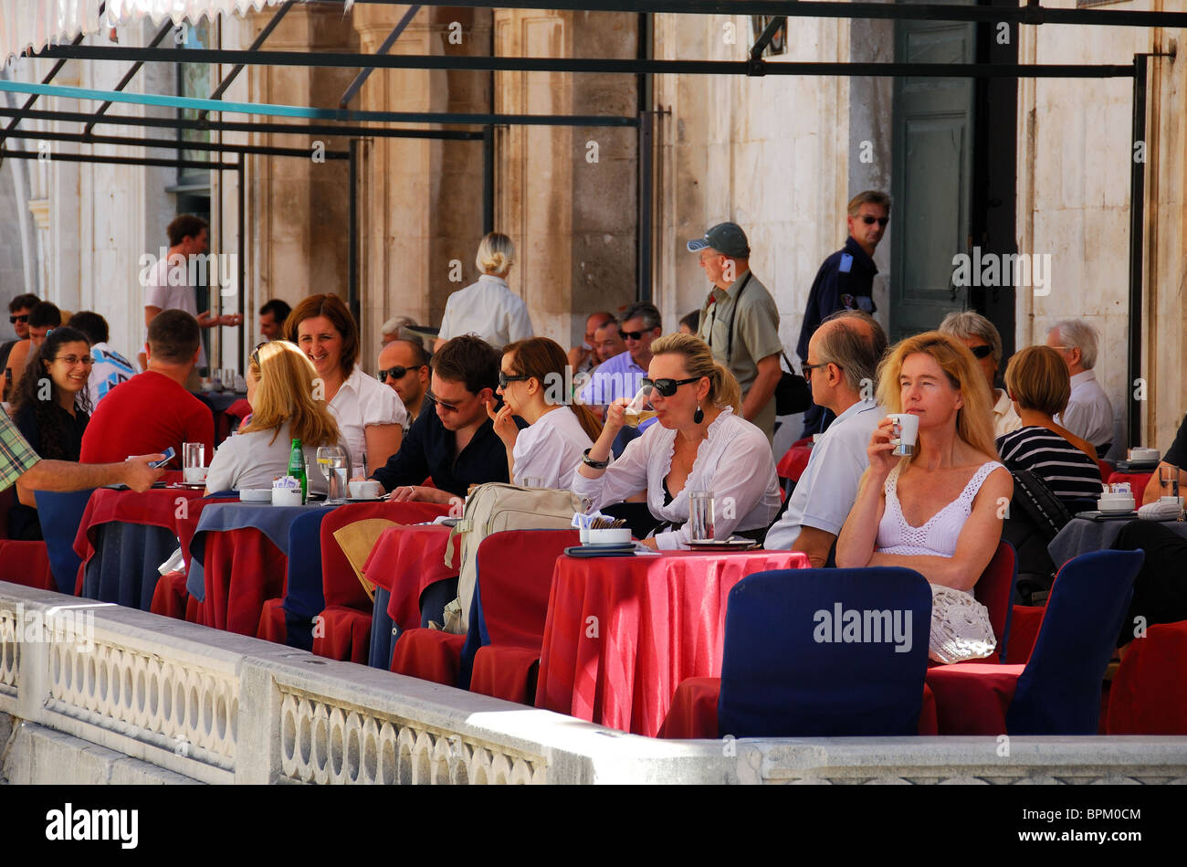DUBROVNIK, Croazia. I clienti di bere sulla terrazza esterna del Gradskavana caffè sulla Piazza Luza nel paese vecchio di Dubrovnik. Foto Stock