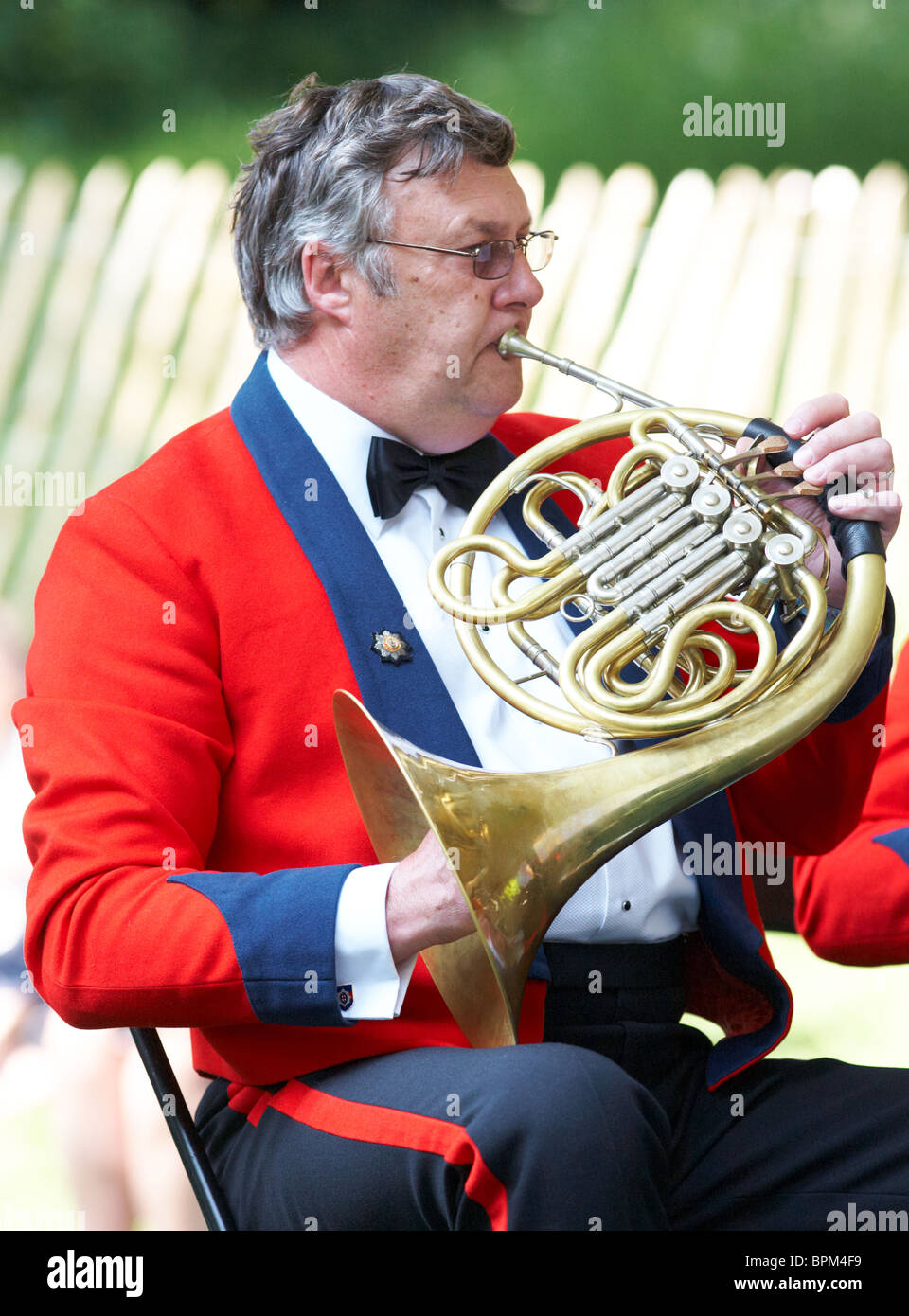 L'uomo gioca il corno francese in un tradizionale gruppo di ottoni al Chelsea Flower Show London REGNO UNITO Foto Stock