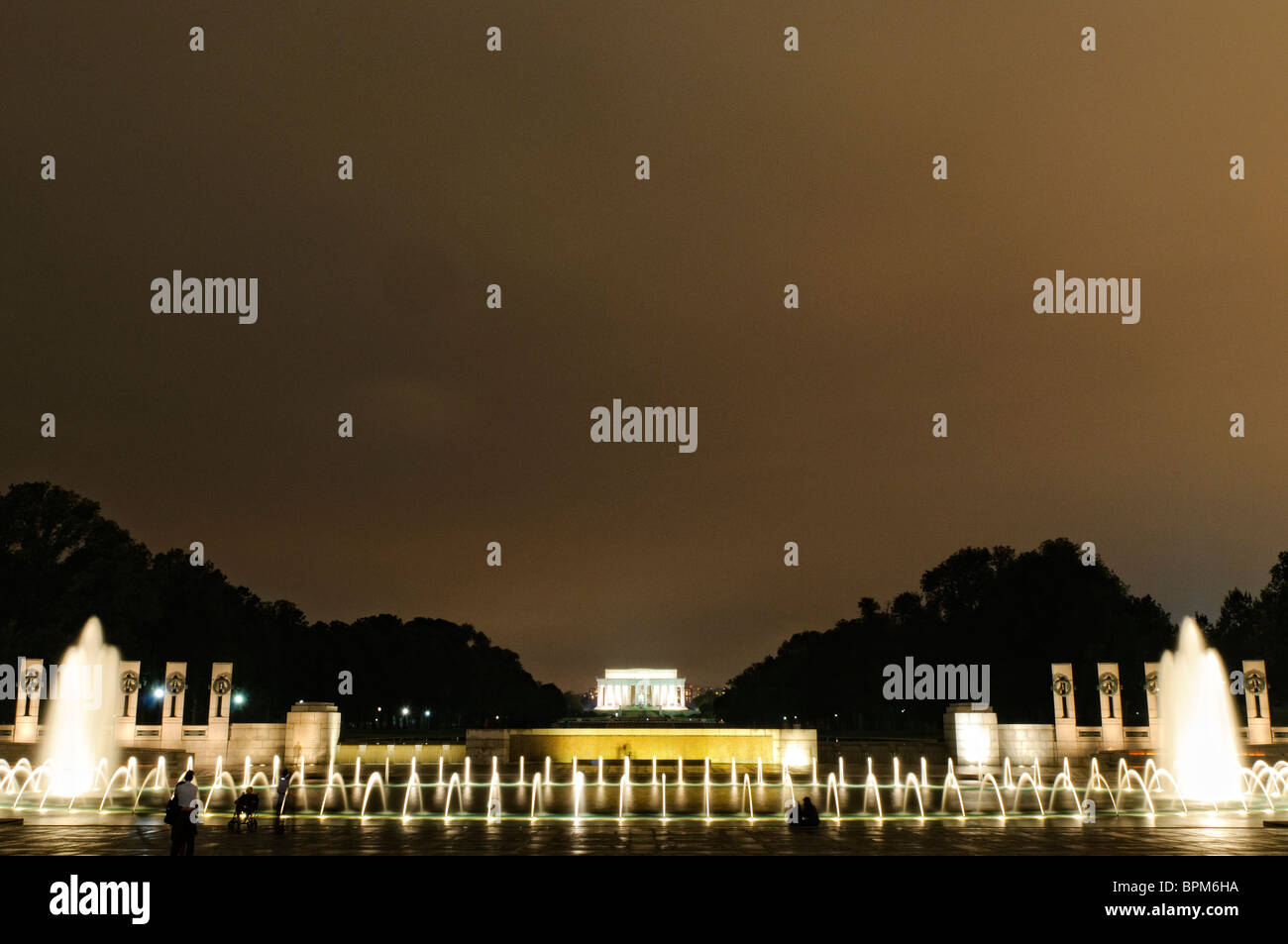 WASHINGTON DC, Stati Uniti: La fontana illuminata del National World War II Memorial sul National Mall di notte. La fontana, una caratteristica centrale del monumento, si riflette splendidamente sull'acqua calma, creando una serena e toccante scena notturna in onore di coloro che hanno prestato servizio nella seconda guerra mondiale Foto Stock