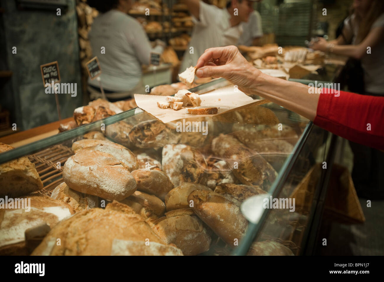 Un visitatore campioni pane a Eataly artigianale di cibo e vini italiani marketplace in New York Foto Stock