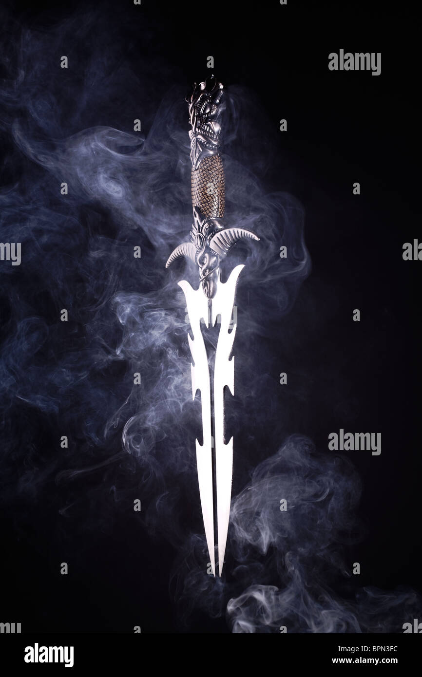 Il fumo e il pugnale. Questa immagine mostra una spada fagocitato in fumo raffigurante macabra, magica umore con un tocco del male. Foto Stock