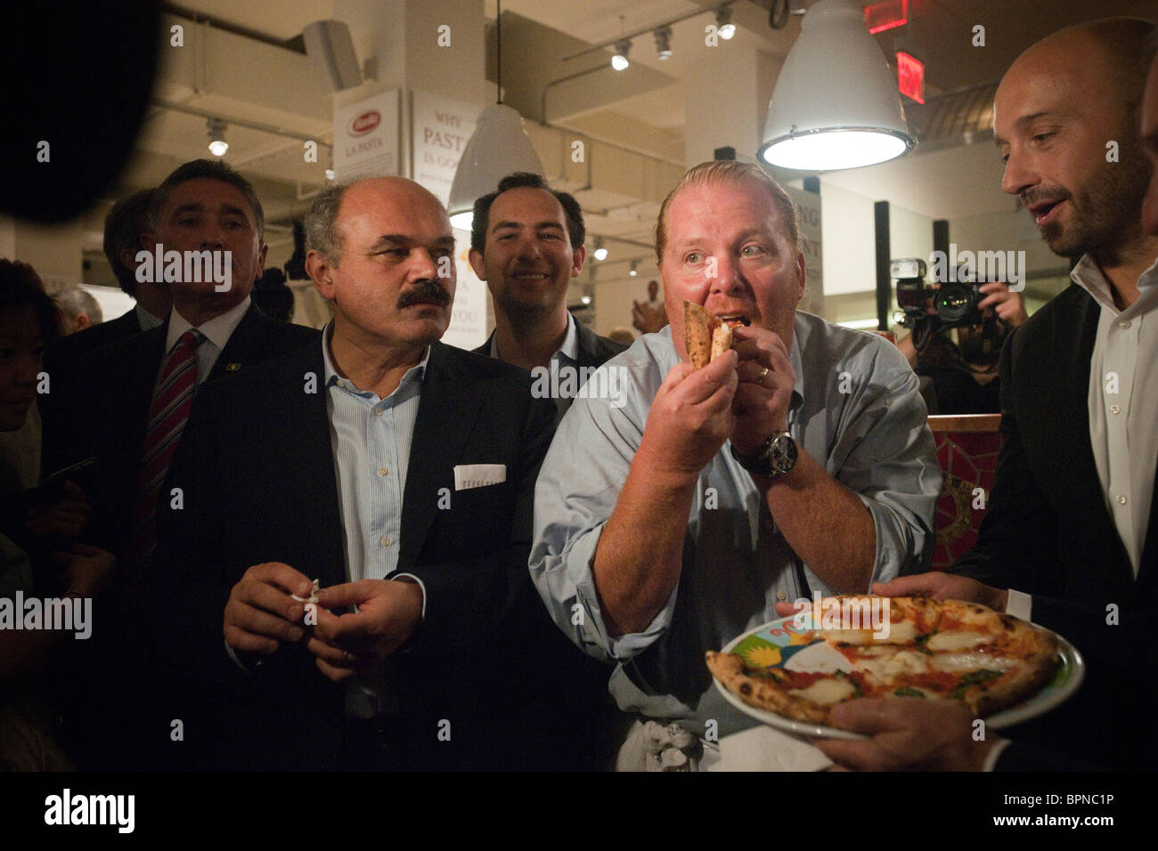 Mario Batali gode di un trancio di pizza a Eataly il cibo italiano e vino marketplace in New York Foto Stock