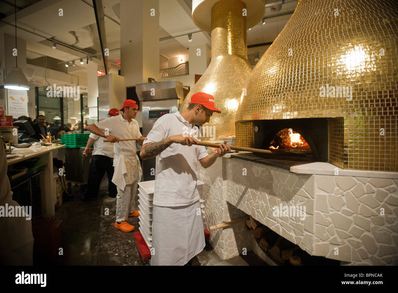 I lavoratori fanno pizze a Eataly artigianale il cibo italiano e vino marketplace in New York Foto Stock