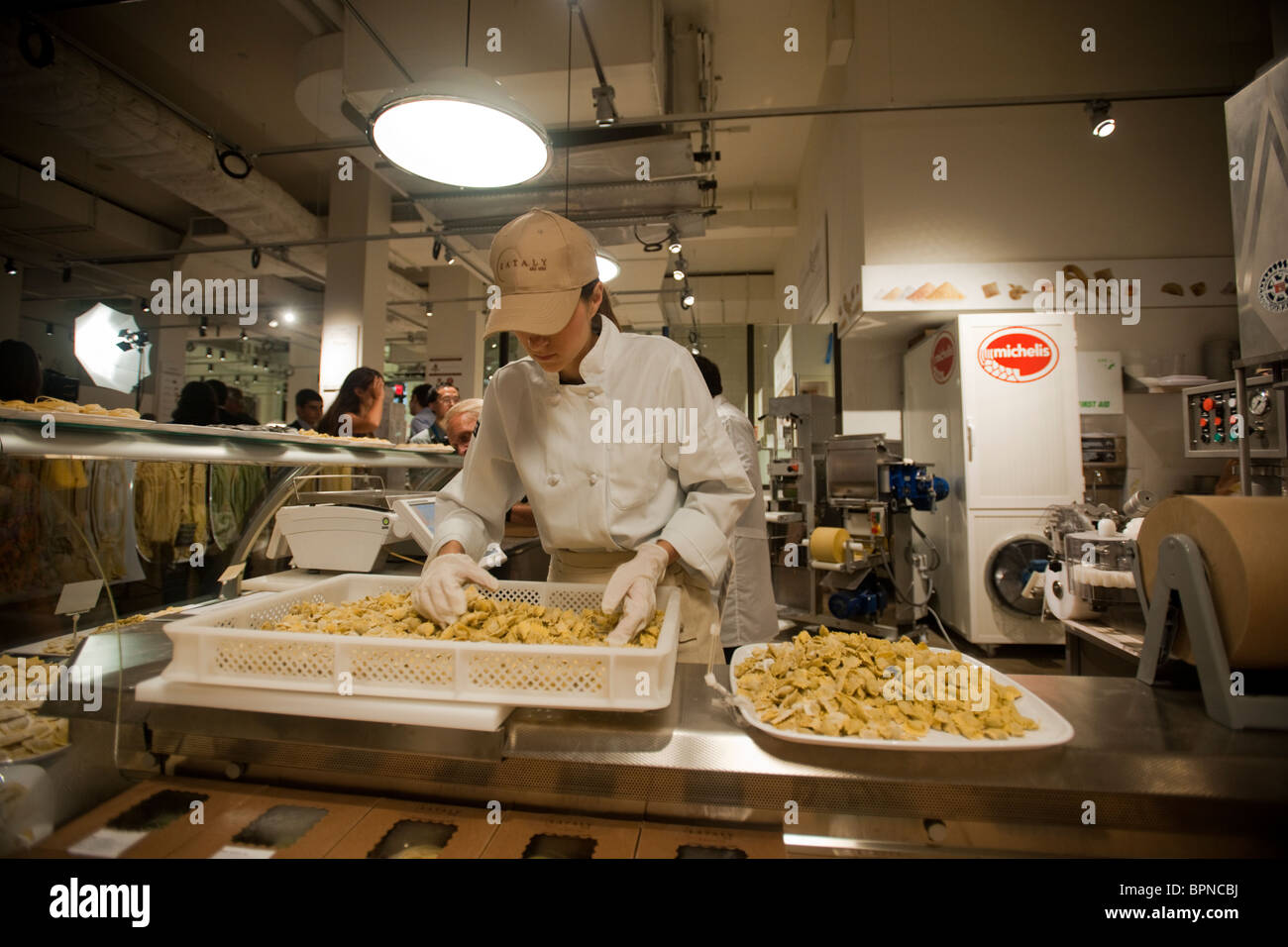 Un lavoratore prepara fresca pasta fatta sul display a Michelis a Eataly marketplace italiani a New York Foto Stock