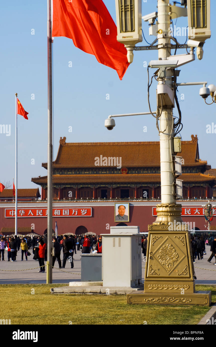 Una bandiera rossa vola sopra le telecamere di sicurezza al di fuori della porta della pace celeste sulla piazza Tianammenthe, Pechino, Cina, Asia. Foto Stock