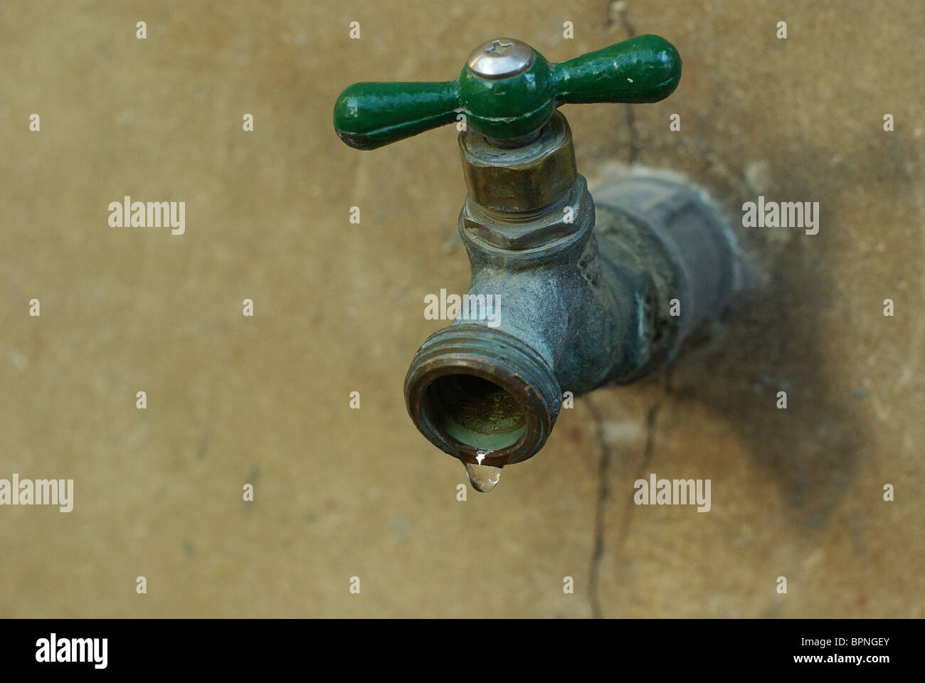 In vecchio stile rubinetto metallico con una goccia d'acqua. Foto Stock