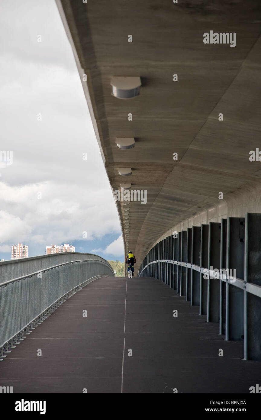 Un ciclista a cavallo su un metro ponte sopra il fiume Fraser in Vancouver, BC Foto Stock