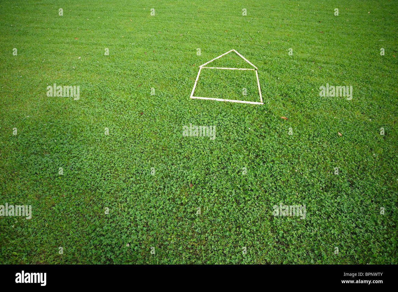 Casa di contorno sul prato verde - concetti Foto Stock