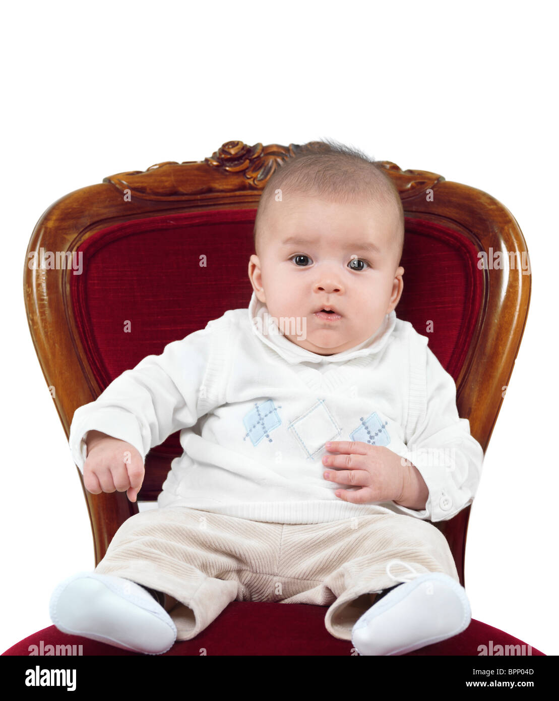 Divertente la foto di una bambina di quattro mesi ragazzo seduto in una sedia come un re su di un trono. Isolato su sfondo bianco. Foto Stock