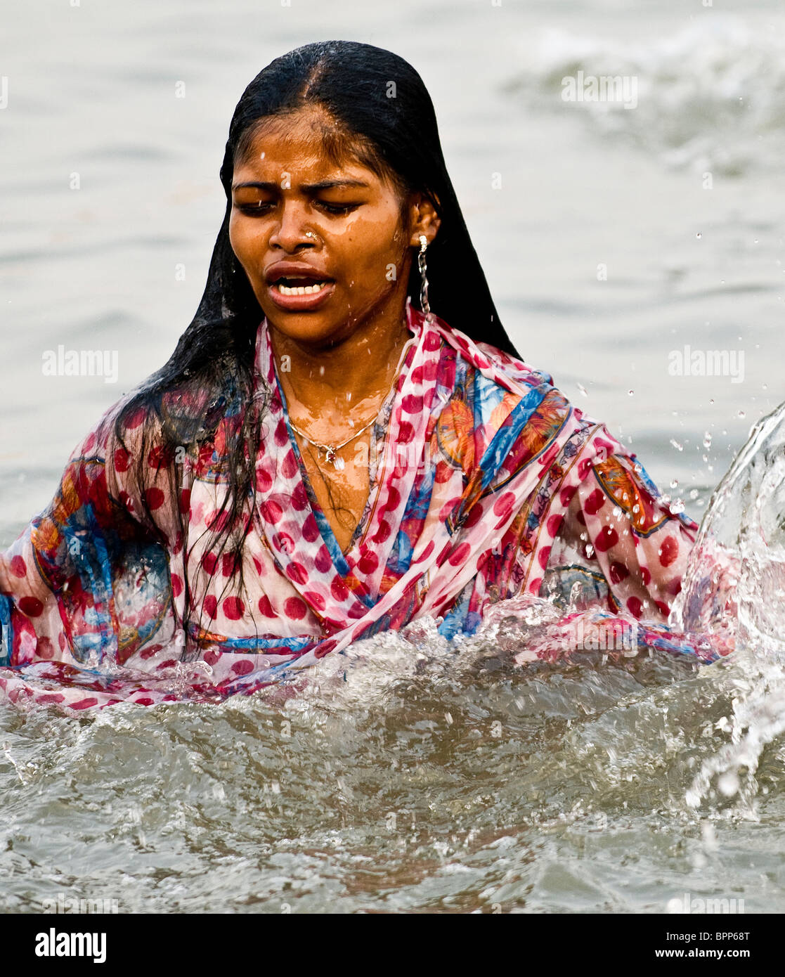 Un pellegrino indù la balneazione nell'acqua santa del Gange. Foto Stock