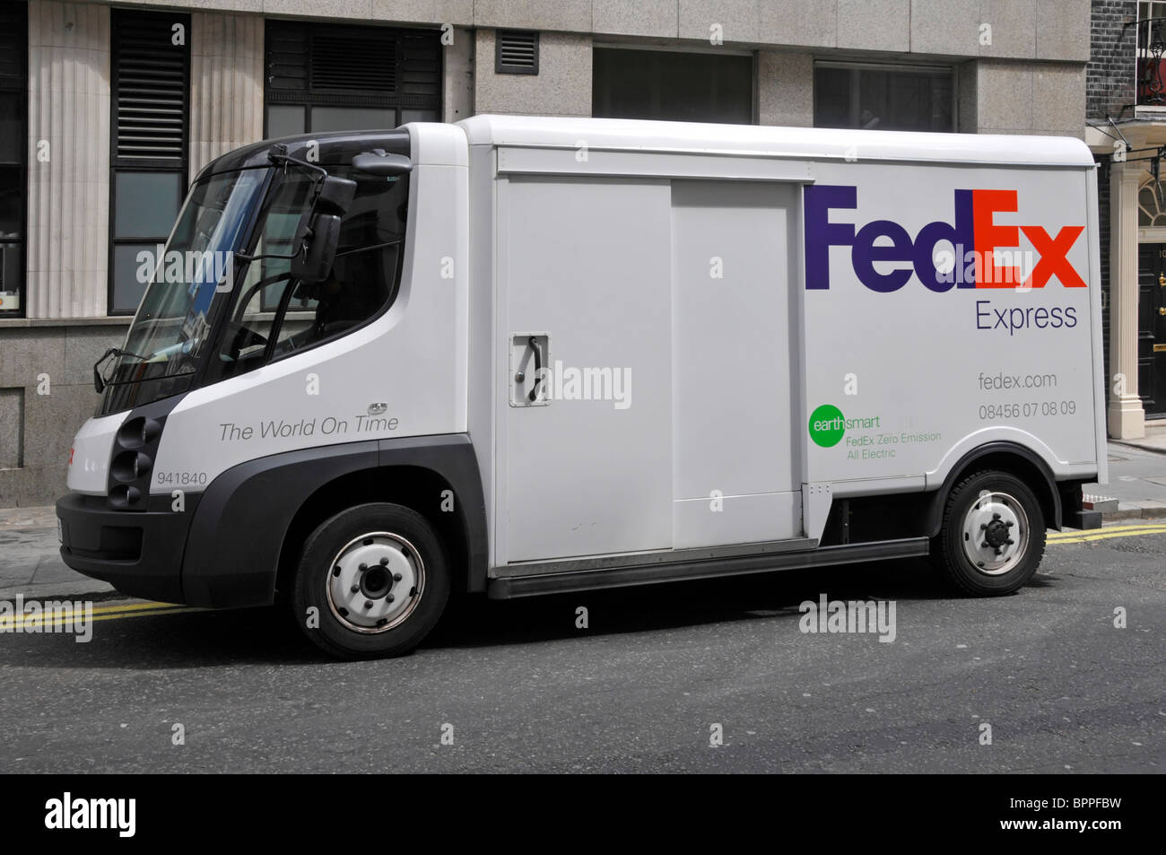 Vista laterale FedEx Express All Electric zero emission Fed ex consegna pacchi business van camion parcheggiato in strada a Londra Inghilterra Regno Unito Foto Stock
