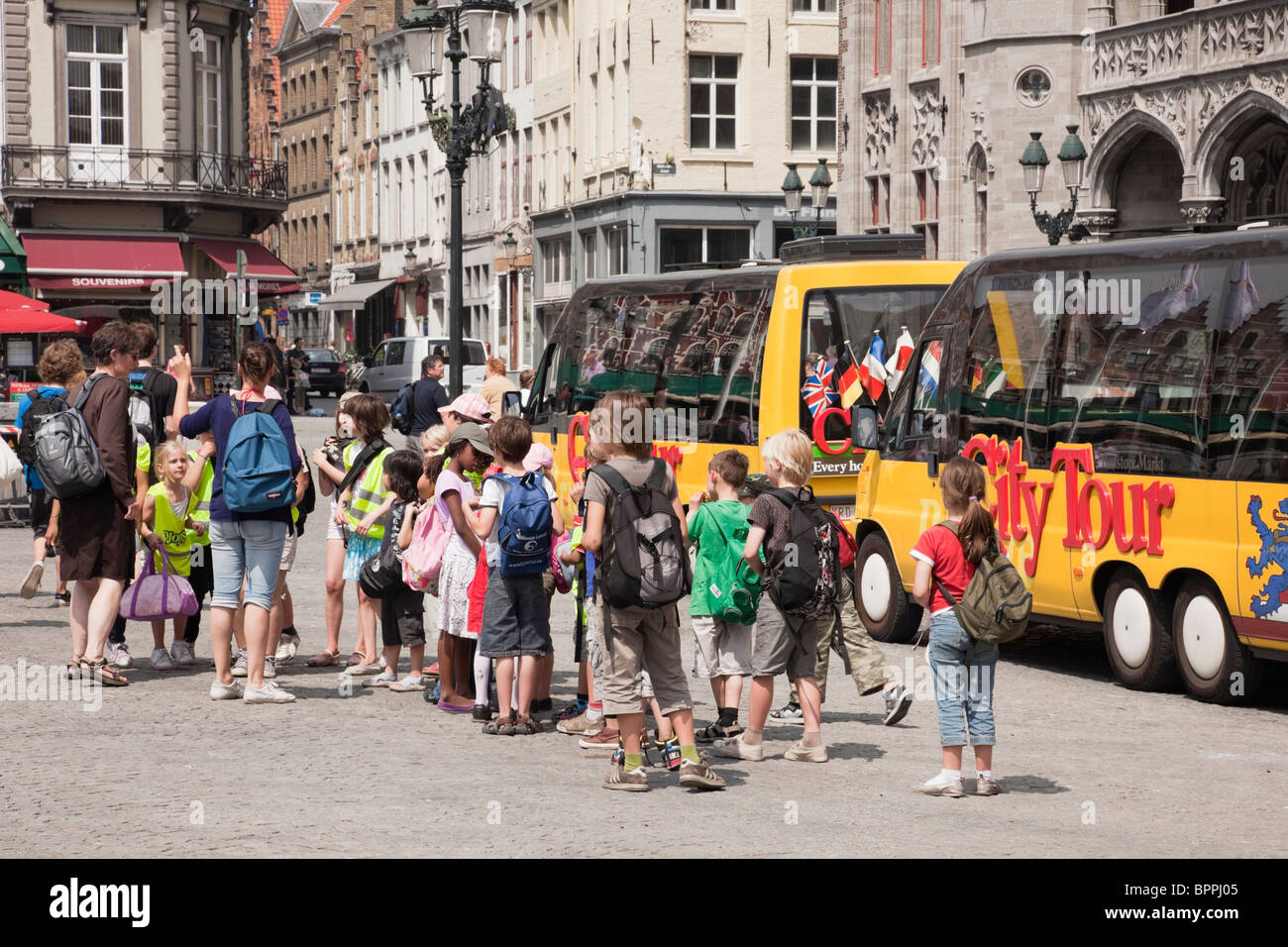 Markt, Bruges, Belgio, Europa. Gruppo di bambini in gita scolastica dal tour della città in autobus Piazza Foto Stock