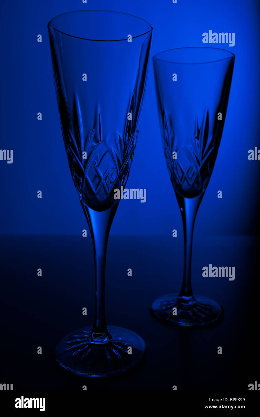 Studio shot di due crystal champagne flauti contro uno sfondo blu Foto Stock