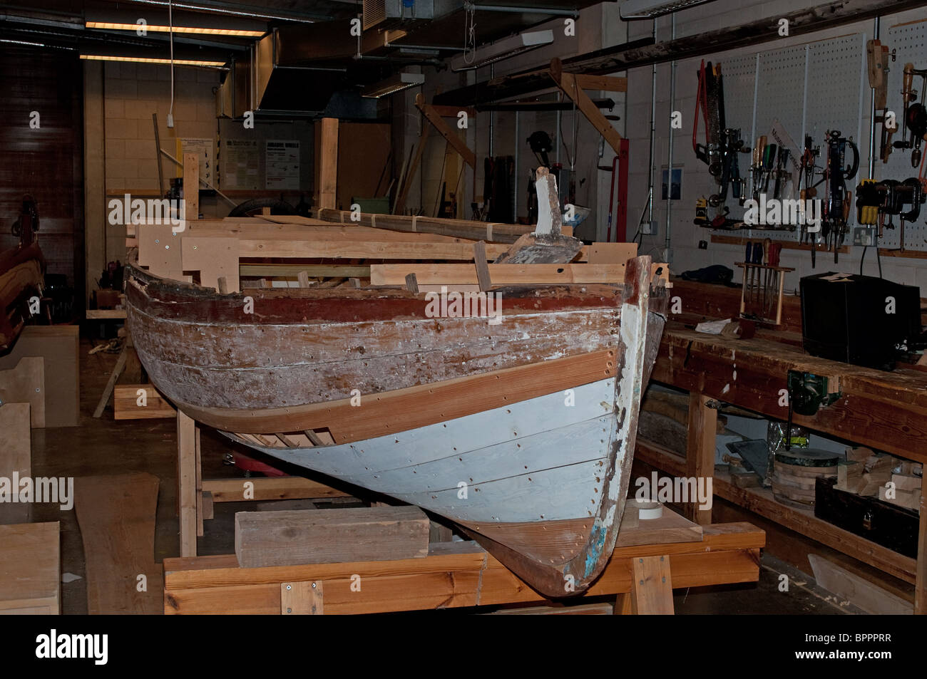 Una barca sotto la riparazione in officina presso il National Maritime museum di Falmouth, Cornwall, Regno Unito Foto Stock