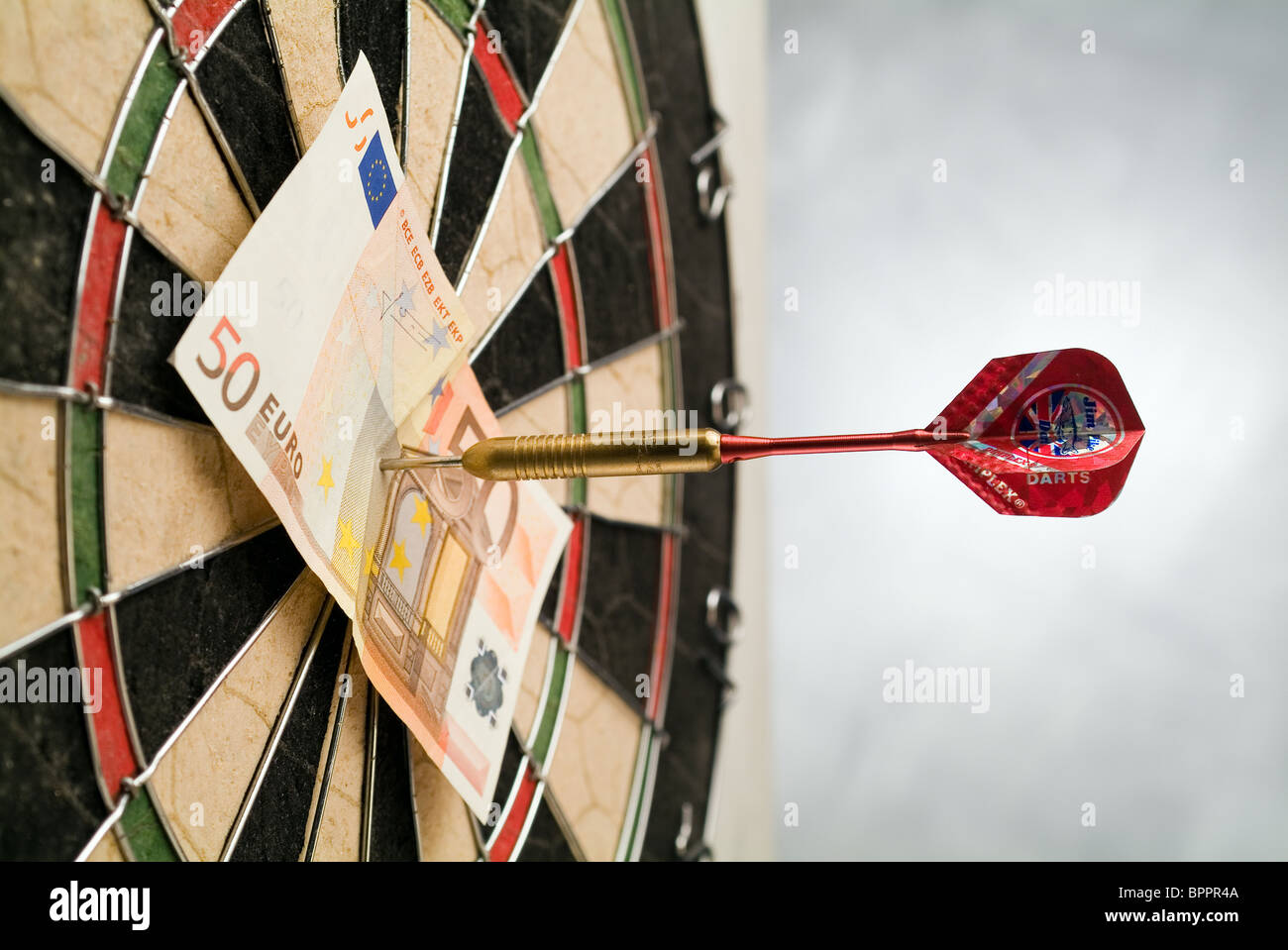 Il pinning Dart una banconota ad una dartboard Foto Stock