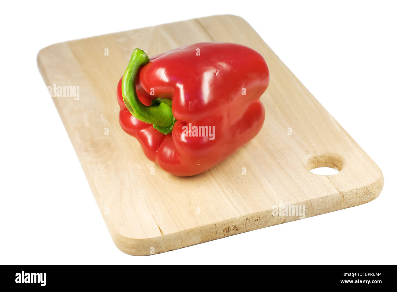 Peperone rosso su un tagliere di legno. Foto Stock