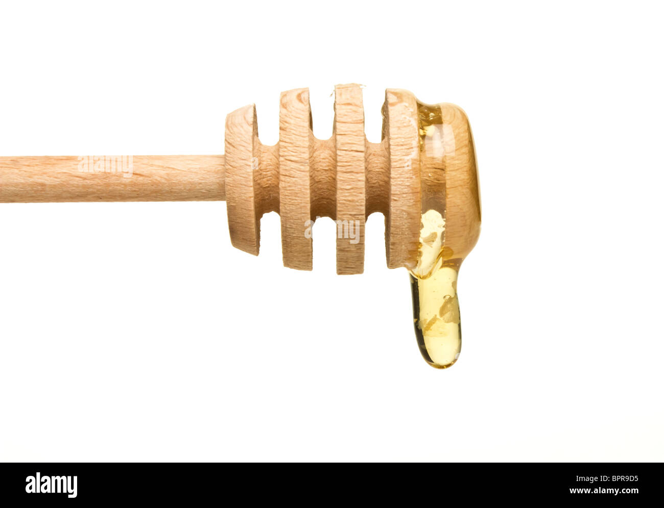 Miele naturale che gocciola dalla drizzler in legno isolato su bianco. Foto Stock
