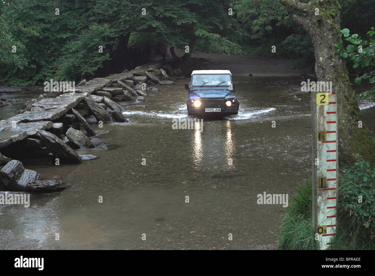 Landrover Varcando il fiume Barle vicino Tarr passi, un battaglio medievale Ponte. Devon. Regno Unito Foto Stock