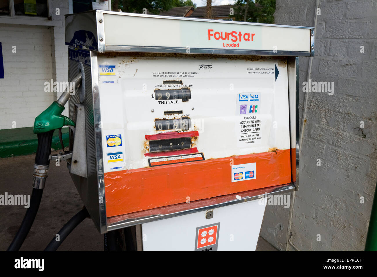 Un vecchio obsoleto il vecchio quattro stelle / pompa vintage a 4 stelle le pompe di benzina in corrispondenza della stazione di riempimento garage piazzale. Regno Unito. Foto Stock