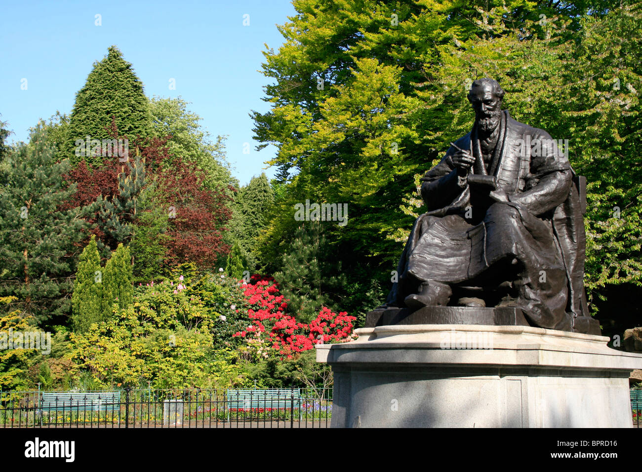Statua di bronzo di William Thomson Lord Kelvin (1824-1907) in vesti accademico con un notebook e penna, Kelvingrove Park, Glasgow Foto Stock