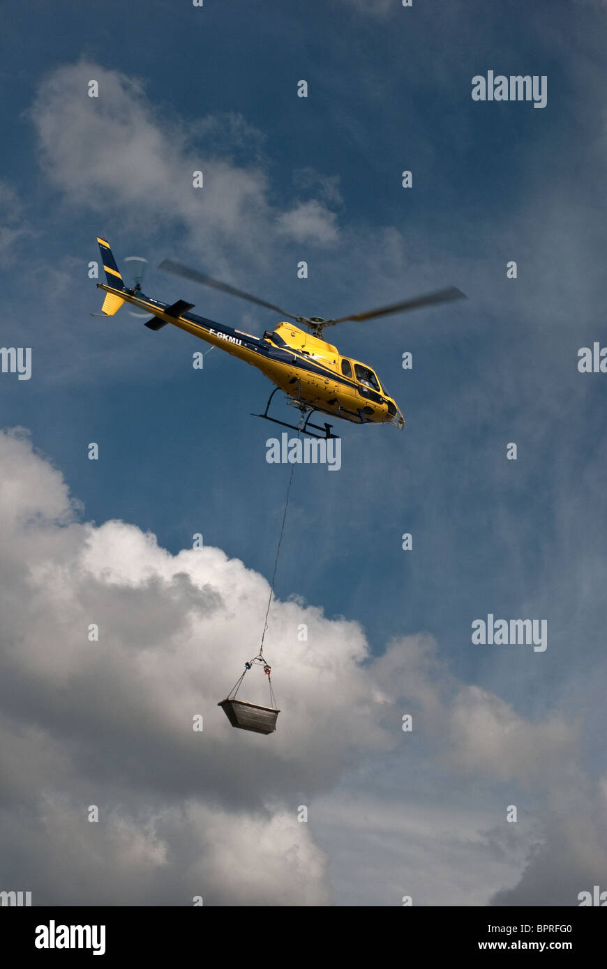 Elicottero che trasporta i sassi per riparare il muro di mare lungo il fiume Roach Essex REGNO UNITO Foto Stock
