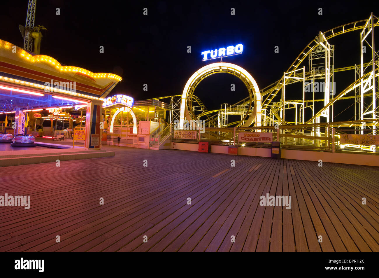 Luna park giostre illuminate di notte sul molo di Brighton East Sussex England Foto Stock