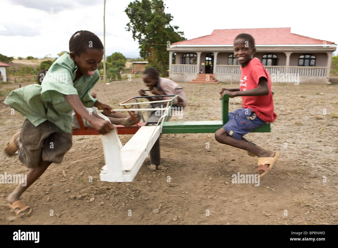 I bambini africani giocare su un merry-go-round in un orfanotrofio in Kilimanjaro, Tanzania. Foto Stock