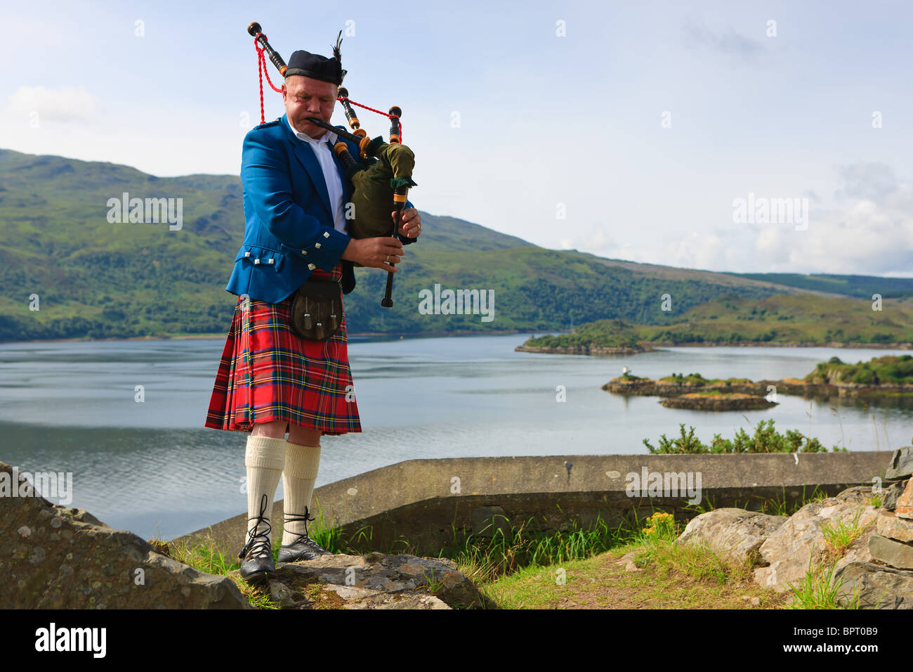 Cornamuse player sulle Highlands scozzesi, vicino all'Isola di Skye Foto Stock