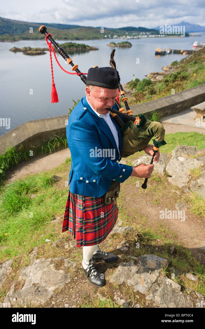 Cornamuse player sulle Highlands scozzesi, vicino all'Isola di Skye Foto Stock
