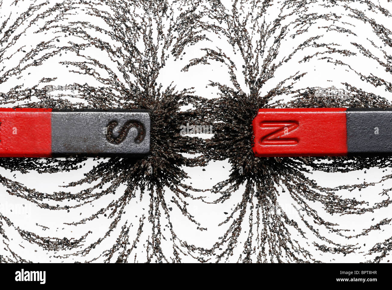 Bar magneti con la limatura di ferro che mostra attrazione magnetica fra i poli opposti Foto Stock