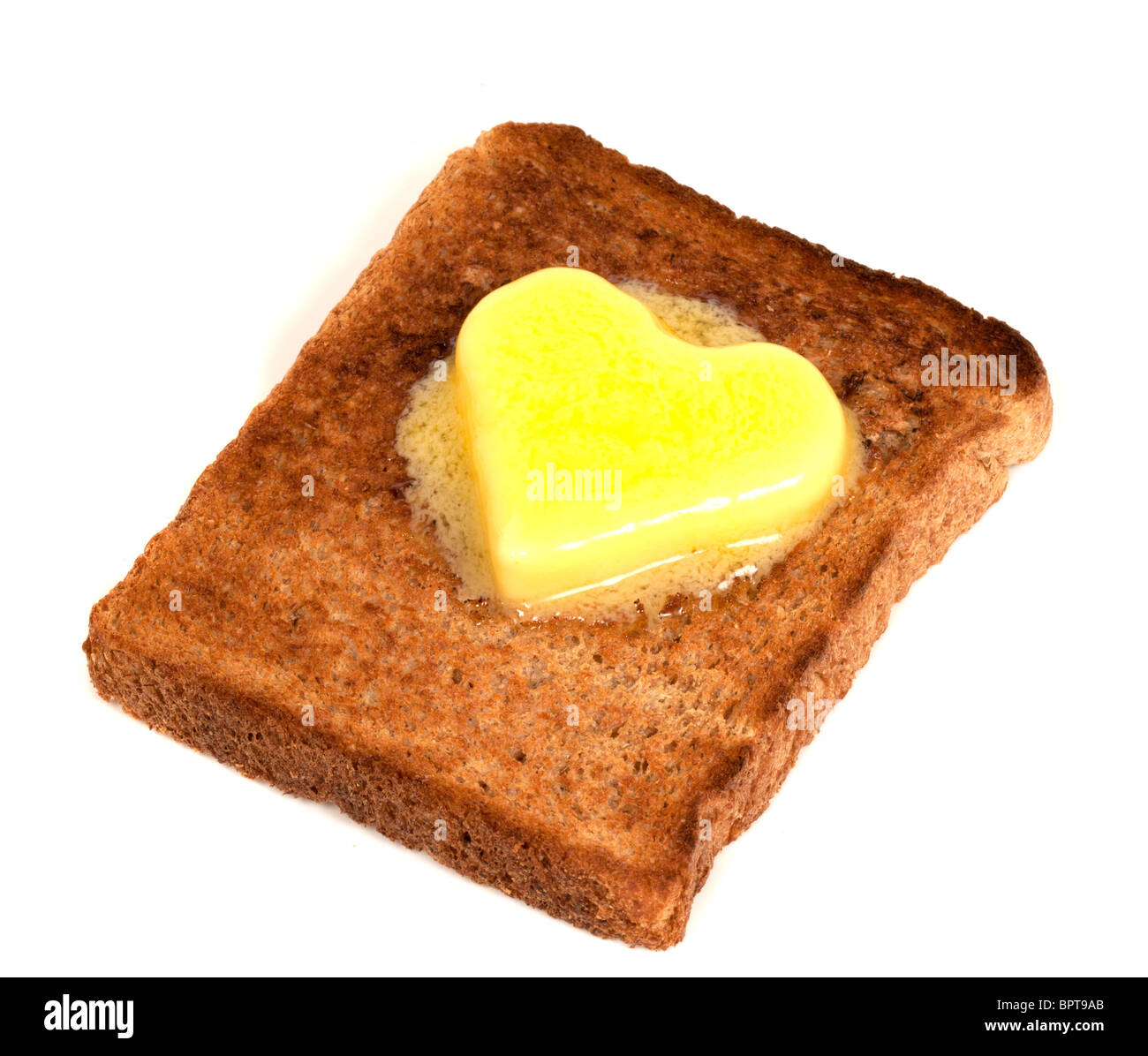 A forma di cuore sul burro Toast integrale su sfondo bianco Foto Stock