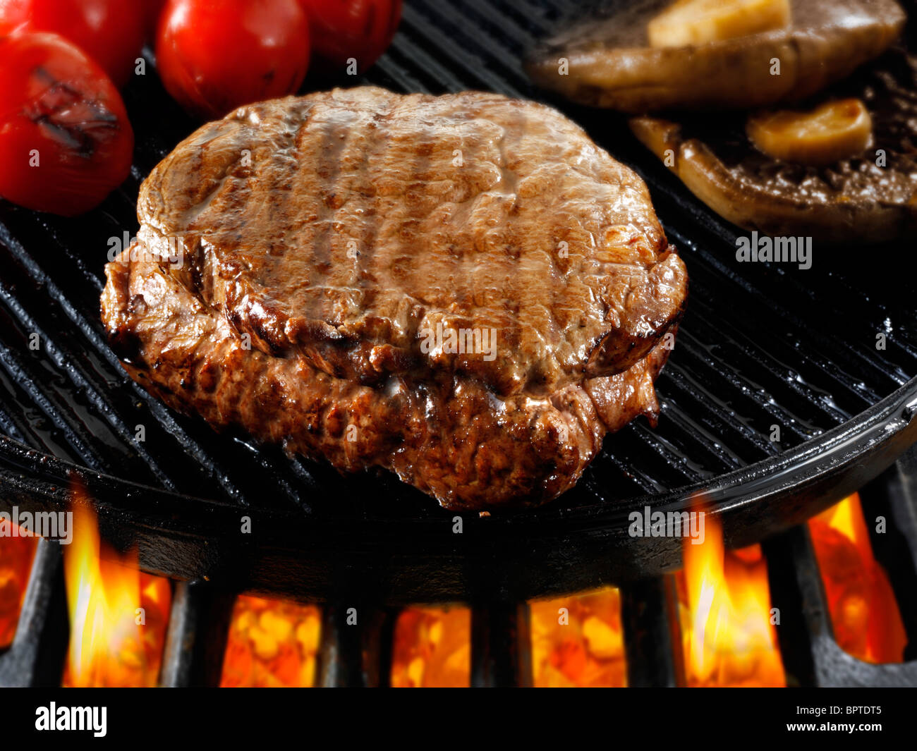 Carni bovine bistecche di filetto e funghi essendo pan fried su un barbecue. Alimenti a base di carne le foto, foto e immagini. Foto Stock