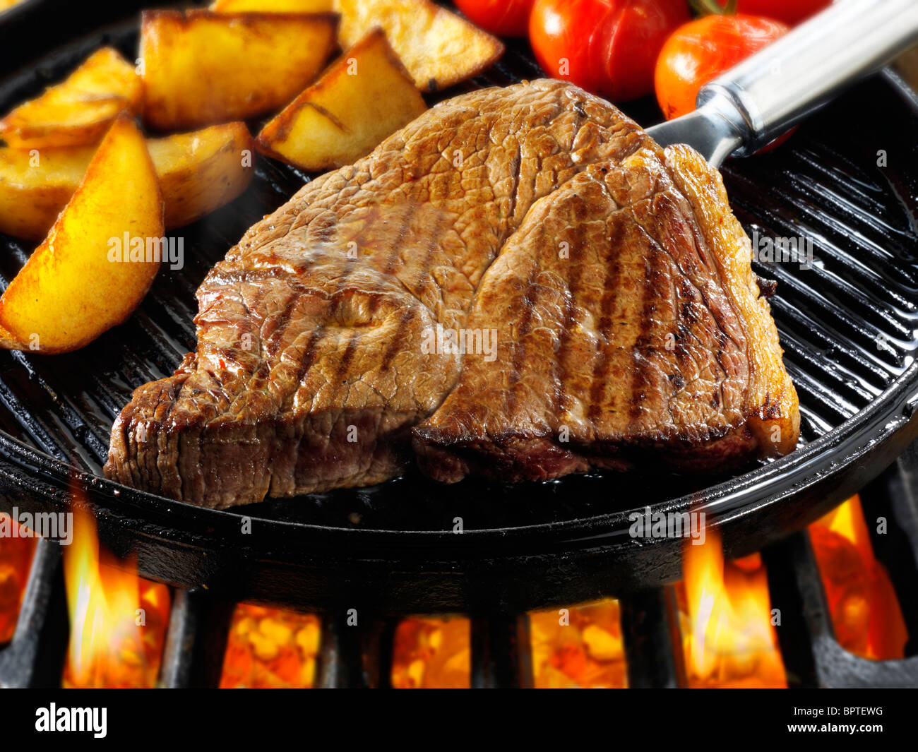 Carni bovine bistecche e trucioli essendo pan fried su un barbecue. Alimenti a base di carne le foto, foto e immagini. Foto Stock