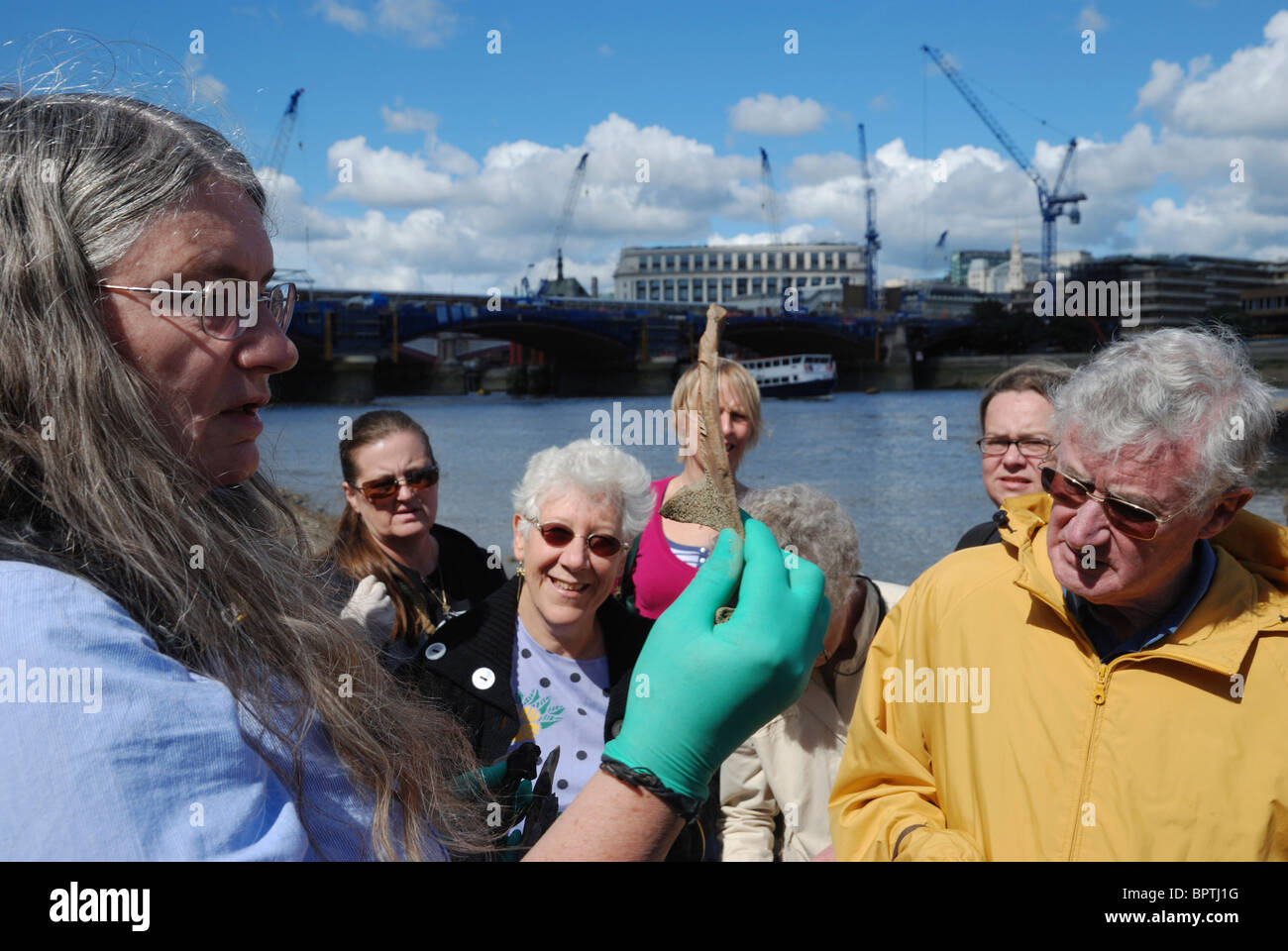 "Thames Beachcombing' sulla riva sud del fiume Tamigi nel centro di Londra, Inghilterra. Foto Stock