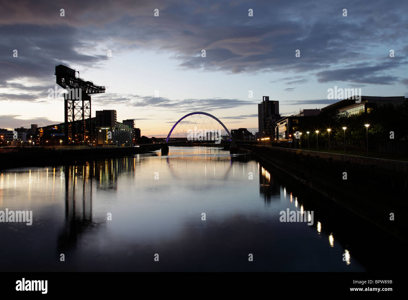 Guardando verso Est lungo il fiume Clyde all'alba verso il Clyde Arc Bridge e Finnieston gru, Glasgow, Scotland Regno Unito Foto Stock