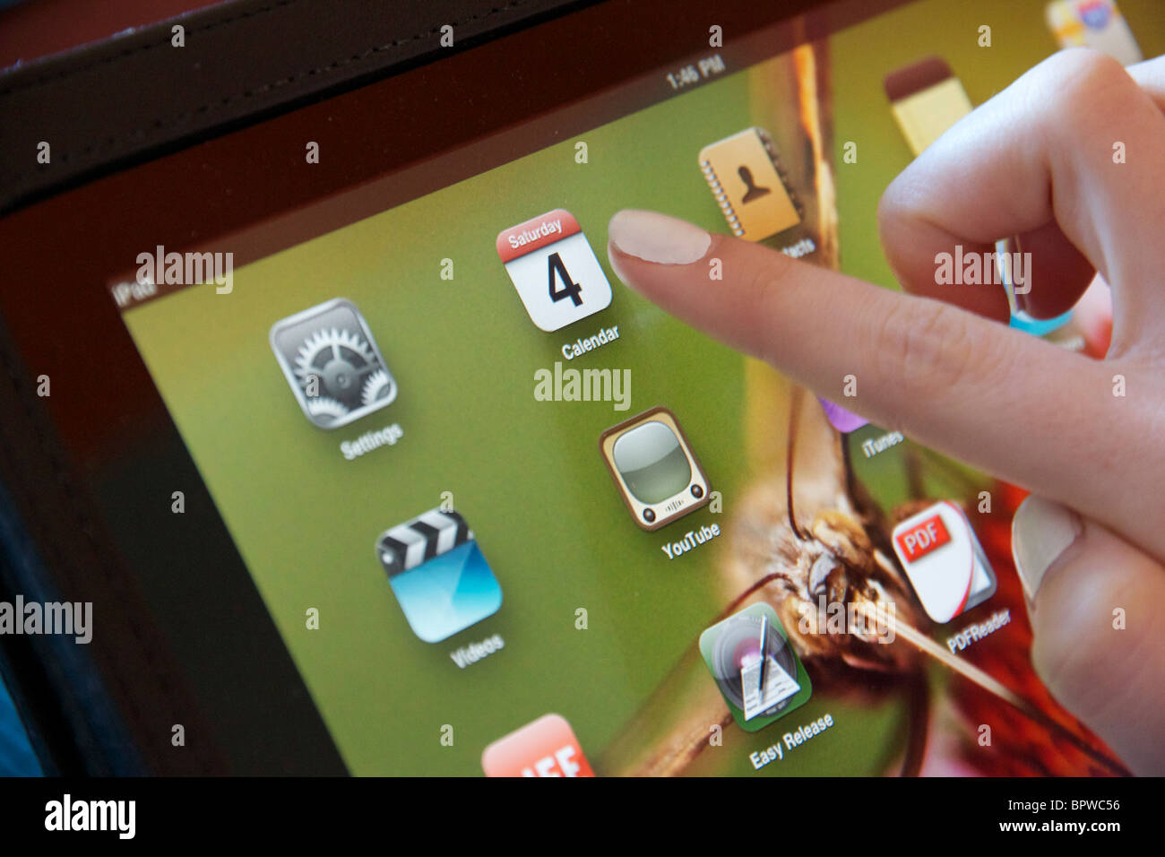 Apple iPad femmina con il dito puntato a icona del calendario. Foto Stock
