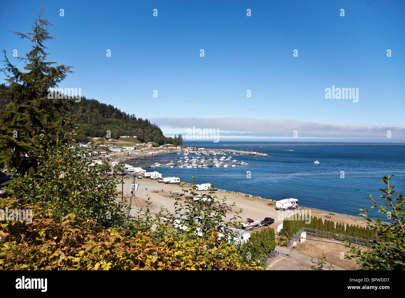 Sunny porto di Sekiu Washington con pontili, barche ormeggiate,waterfront RV park & distante nebbia banca sopra stretto di Juan de Fuca Foto Stock