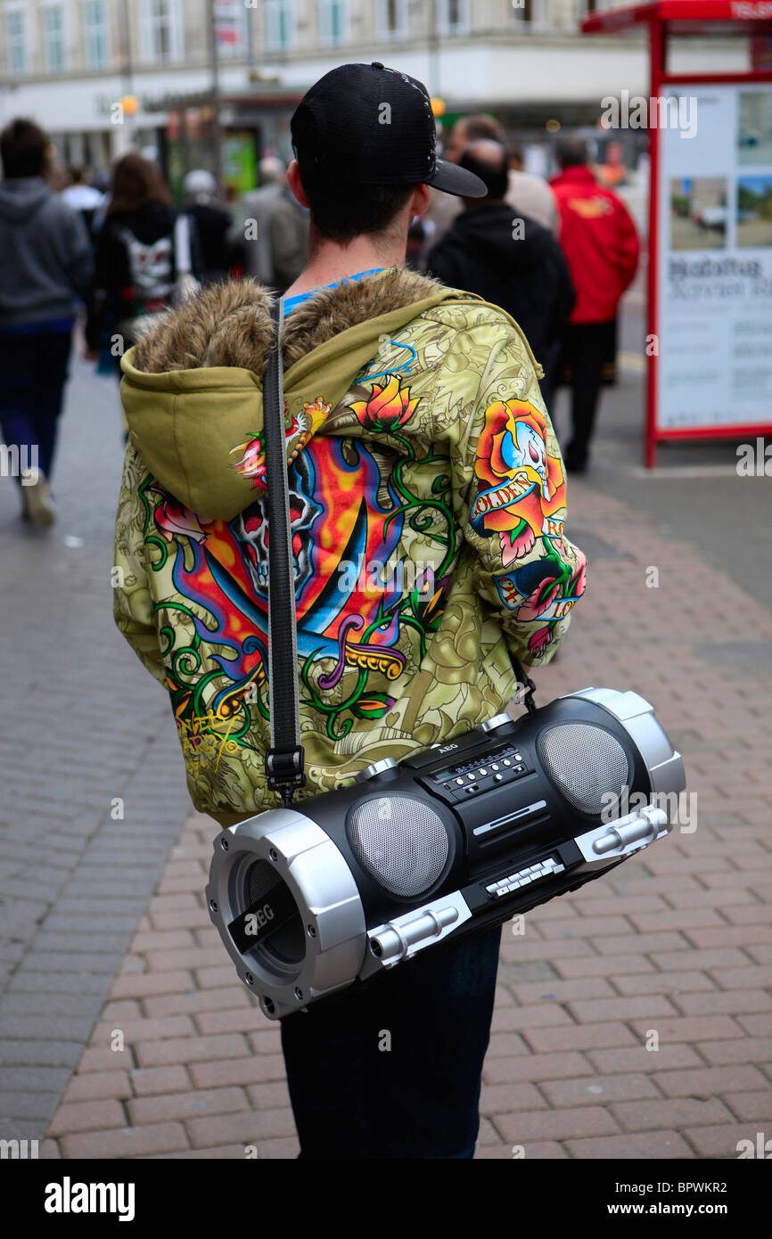 Una persona giovane con un boombox cammina per le strade del centro città di Belfast,, Irlanda del Nord, Regno Unito, su ottobre 04 2009. Foto Stock