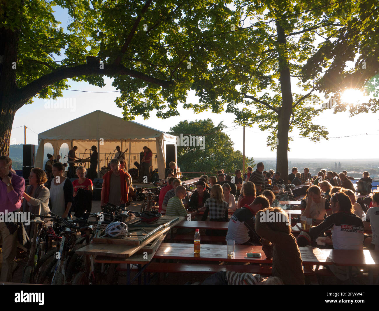 Seduti al sole di sera, i visitatori di Friburgo Schlossberg festival in Germania Meridionale per ascoltare un gruppo musicale. Foto Stock