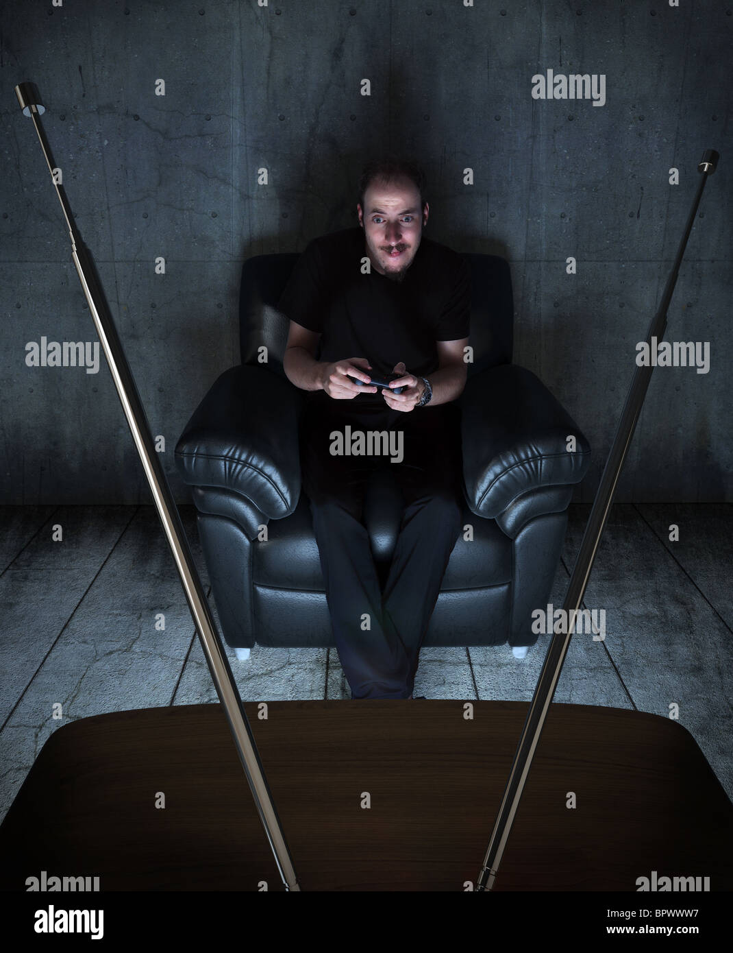 I giovani adulti per giocare con i videogiochi in un grungy e camera oscura alleggerita solo tramite lo schermo TV Foto Stock