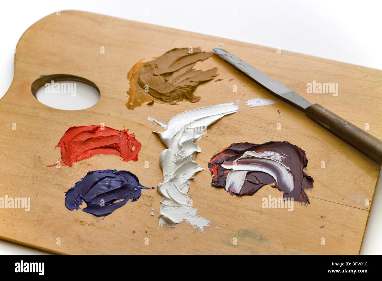 Tavolozza di artisti con daubs della pittura a olio su sfondo bianco Foto Stock